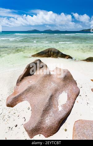 Anse Grosse Roche in La Digue, Seychelles with clear water and granite rocks Stock Photo