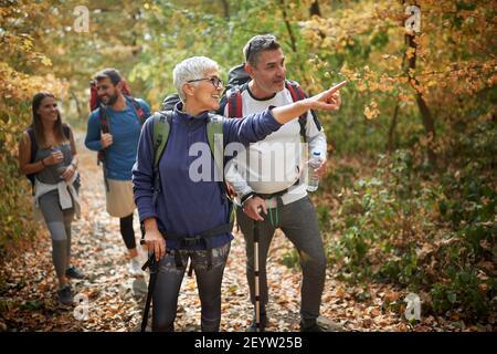 Premium Photo  Attractive happy woman backpacker hiking mountain trail,  walking on grassy hill, using trekking sticks, smiling to the camera and  showing thumbs up. outdoor activity, tourism concept