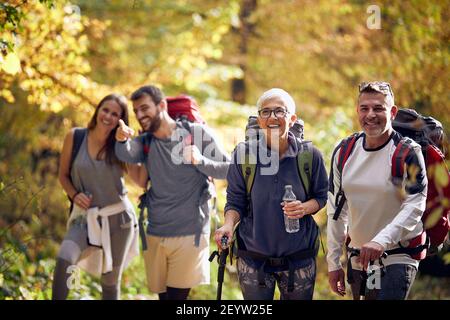 Happy group of people hiking at autumn in nature Stock Photo