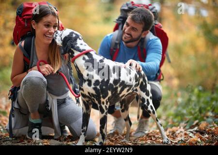 Cheerful man and woman hiking and enjoying with dog Stock Photo