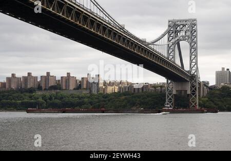 Tuck boat and barge under George Washington Bridge Stock Photo