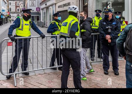 Cork, Ireland. 6th Mar, 2021. Around 700 people attended an anti-lockdown rally held in Cork city centre today. Gardai were prepared for any trouble with officers in the city centre from 10.30am. A member of the public was ushered away from the protest by uniformed Gardai. Credit: AG News/Alamy Live News Stock Photo