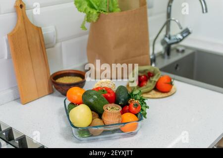 World Vegan Day. Different raw vegetables, herbs and cereals on the kitchen table. . Fresh raw food seasonal vegetables on home kitchen. Vegetarian Stock Photo
