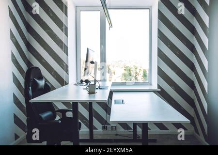 Empty office space while officer is working from home to avoid corona virus. Open space office in loft style in new normal. Working In An Empty Office Stock Photo
