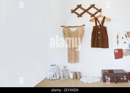 Cute Nursery Decorating Ideas, Baby Room Designs decor. Toddler baby Organic cotton clothes hanging on the rack and rustic retro accessories on white Stock Photo