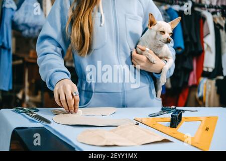 Small business, fashion designer, Tailor working, dressmaker workplace. Candid portrait of fashion designer creating outfit, tailor sews dress on the Stock Photo