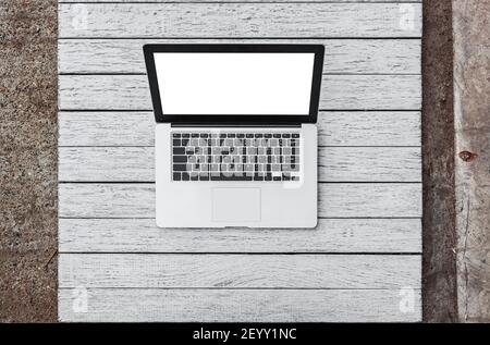 Open laptop with isolated screen on wooden desk Stock Photo