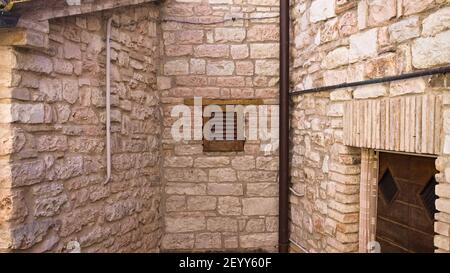 Isolated tiny window with wooden shutters in a medieval brick building (Marche, Italy, Europe) Stock Photo