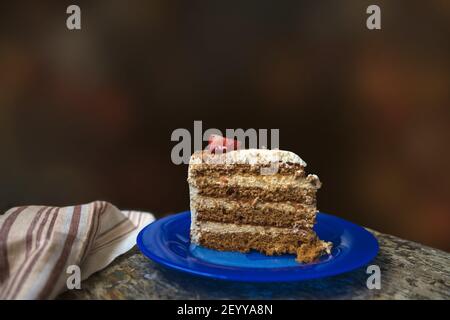 piece of homemade birthday cake on the blue plate with dark background Stock Photo