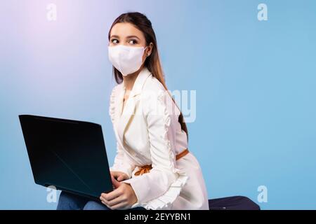 Businesswoman sitting on luggage bag, suitcase. An attractive woman is preparing for a vacation, travel after the end of the pandemic due to covid-19 Stock Photo