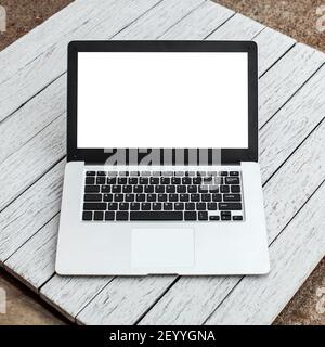 Open laptop with isolated screen on wooden desk Stock Photo