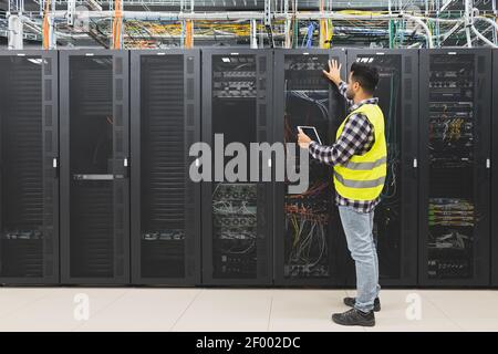 Male informatic engineer working inside server room database Stock Photo
