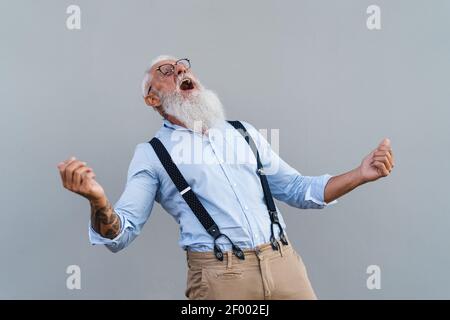 Happy trendy senior man having fun dancing in front camera - Fashion elderly male lifestyle concept Stock Photo