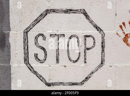 Stop sign painted on wall, texture and background, traffic Stock Photo