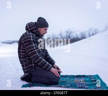 Muslim traveler praying in winter mountain , high quality  Stock Photo