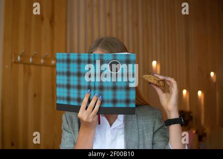 Foods to Boost Brain and Memory. Foods linked to better brainpower. Young girl, teen, student with open book in her hands and healthy grain cookies Stock Photo