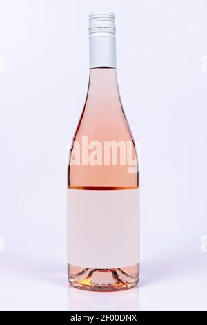 Beautiful burgundy bottle of rose wine on white surface and background Stock Photo