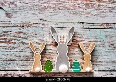 Three wooden Easter bunnies from behind with decoration. Stock Photo