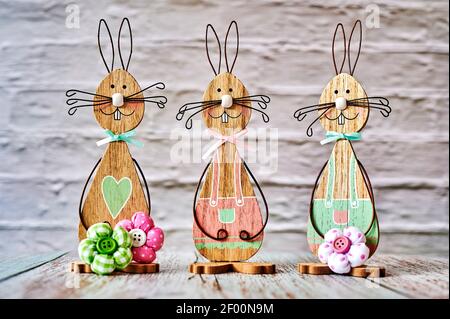 Three wooden Easter bunnies with decoration. Stock Photo