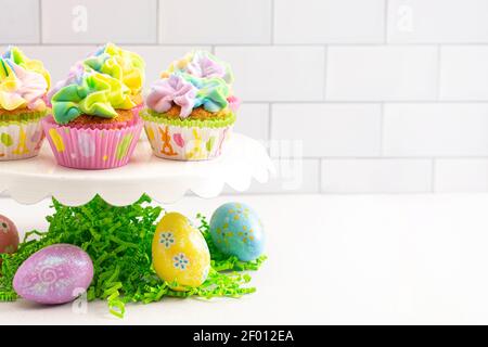 Pastel Rainbow Frosted Easter Cupcakes  on a White Kitchen Counter Stock Photo