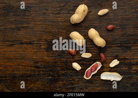 Top view of Peanuts hulls nut shell and peeled peanuts on wooden background Stock Photo