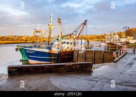 Fishing trawlers moored at Kirkcudbright harbour on the River Dee at sunset in winter, Dumfries and Galloway, Scotland Stock Photo