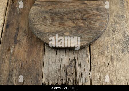 Wooden tray on a wooden background. Boards. Light brown board. Round wooden plate. Stock Photo