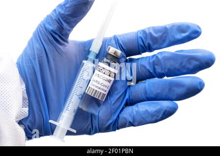 Coronavirus vaccine in doctor hand isolated on white, bottle and syringe in gloved palm close-up. Concept of COVID-19 vaccine injection, corona virus Stock Photo