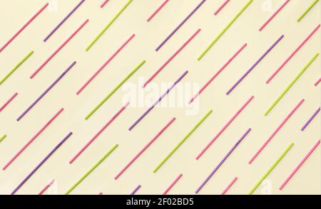 Multi colored paper straws lined up  in a pattern on a champagne background. Flat lay view, modern creative concept. Stock Photo