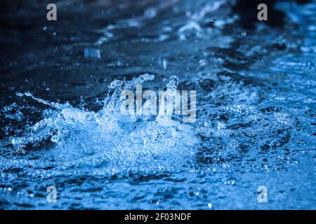 Close up of flowing water in a fountain producing small pearls and nice shapes Stock Photo