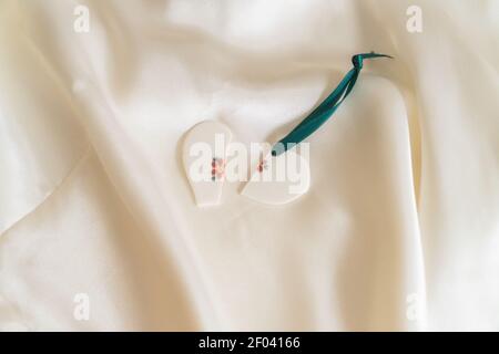 state of mind: a broken heart and a treasured ring nestled on white satin Stock Photo