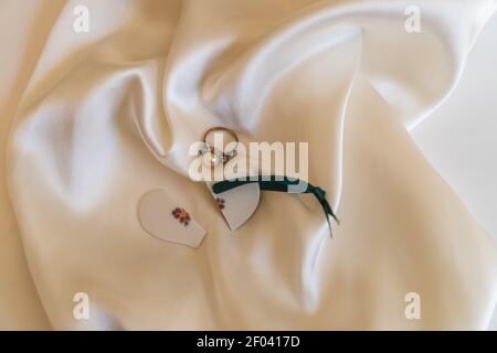 state of mind: a broken heart and a treasured ring nestled on white satin Stock Photo