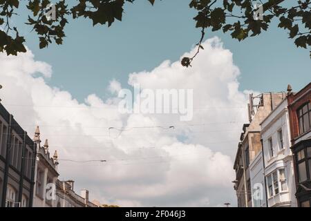 The old buildings and the cable lines under the clouds in the sky captured in the Queen St. Cardiff, Wales Stock Photo