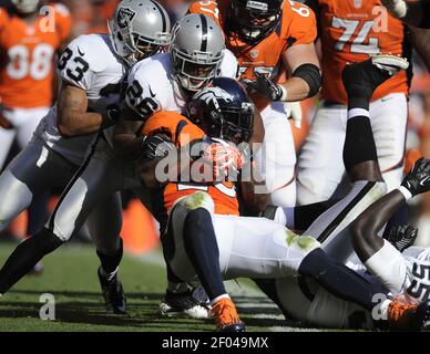 Denver Broncos running back Willis McGahee (L) scores against Buffalo Bills  linebacker Reggie Torbor on a 13-yard touchdown pass in the second quarter  at Sports Authority Field at Mile High in Denver