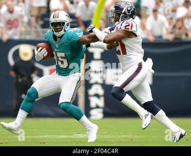 Miami Dolphins' Davone Bess (15) pulls on Chicago Bears' Charles Tillman  (33) jersey after Tillman intercepted a pass as Olin Kreutz (57) applies  pressure during a NFL football game in Miami, Thursday