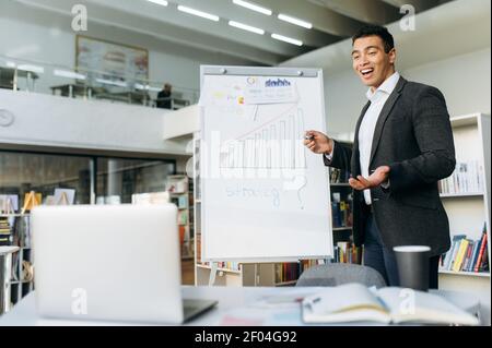 Attractive male business leader distantly working, communicate with colleagues by video call. Successful businessman make a presentation at online briefing, discussing work project Stock Photo