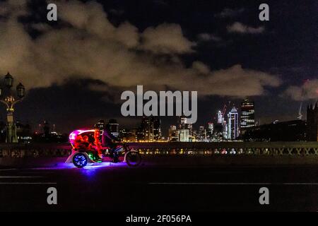 London, UK, March 6, 2021. Commuters cross Westminster Bridge on a rickshaw in the night during an ongoing third Coronavirus lockdown. The Street is usually busy with crowds of people. The Prime Minister Boris Johnson has set a road map on easing the restrictions. Credit: Dominika Zarzycka/Alamy Live News Stock Photo