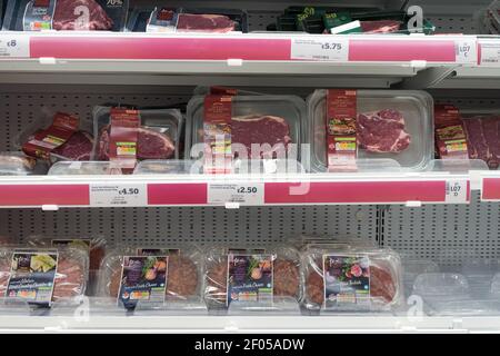 prepacked beef steaks and minced beef burgers display on shelves for sale at sainsbury's supermarket Stock Photo