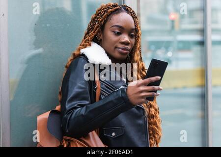 Young female sitting at table and surfing Internet on netbook enjoying summer weekend in backyard tent Stock Photo