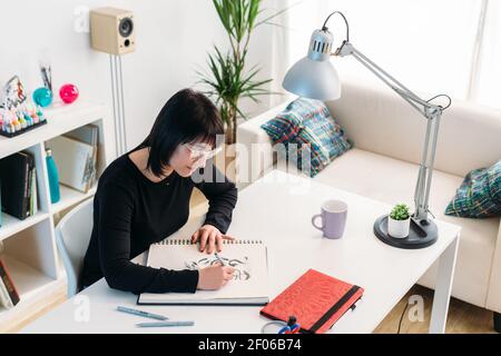 Female designer near big paper sheet with project plan in office