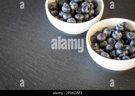 Fresh and healthy blueberries in bowls standing on a stone counter. Place for your own inscription Stock Photo