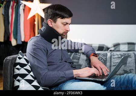 Business man overtime work massaging his neck while suffering from pain, uses a neck collar to relieve muscle tension. Man with health problems Stock Photo