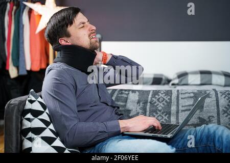 Business man overtime work massaging his neck while suffering from pain, uses a neck collar to relieve muscle tension. Man with health problems Stock Photo