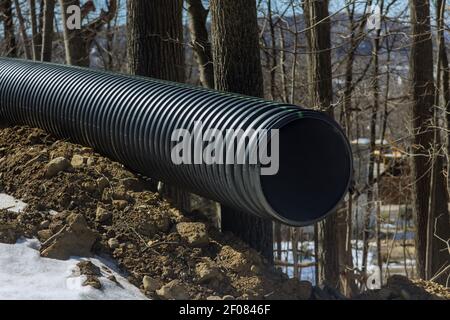 Plastic main black pipes on heap of polyethylene pipes for a drain supply system for laying of city communications Stock Photo