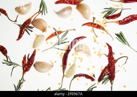 Garlic cloves with rosemary and dried chili pepper on white background. Stock Photo