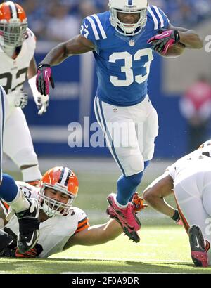 Cleveland Browns running back Trent Richardson (33) jumps through the line  of scrimmage against Cleveland Browns defensive tackle John Hughes (93) on  Sunday, October 21, 2012, in Indianapolis, Indiana. (Photo by Sam