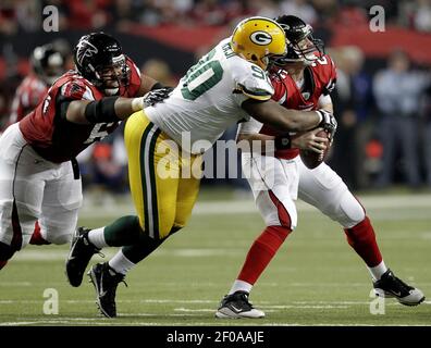 Philadelphia Eagles quarterback Michael Vick gains yardage as dodges around  tackle Todd Herremans who takes down Green Bay Packers B. J. Raji (90)  during fourth quarter Philadelphia Eagles-Green Bay Packers game action