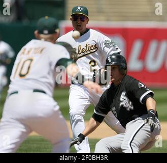 During a rundown, Chicago White Sox player Jerry Dybzinski (20) stops short  of second base as Baltimore Orioles second baseman Rich Dauer (25) fires  for home plate to throw out Vance Law