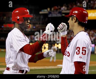 Philadelphia Phillies' Domonic Brown is congratulated in the dugout after  scoring on a single hit by Jerad Eickhoff in the fourth inning of a  baseball game against the Miami Marlins, Friday, Aug.