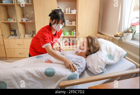 24 February 2021, Saxony, Auerbach (vogtland): Vietnamese Oanh Nguyen cares for training dummy Elvira in the training room of Arbeiterwohlfahrt Vogtland (AWO). Three young women came to Vogtland from their home country Vietnam for training in 2017. This is now finished - since the beginning of March, they have been working for the AWO as skilled nursing staff. These are in short supply and the need is growing steadily due to the aging population. Four years ago, they were the first, now almost half of the trainees in the field of care at the social association come from Vietnam: 20 Vietnamese Stock Photo